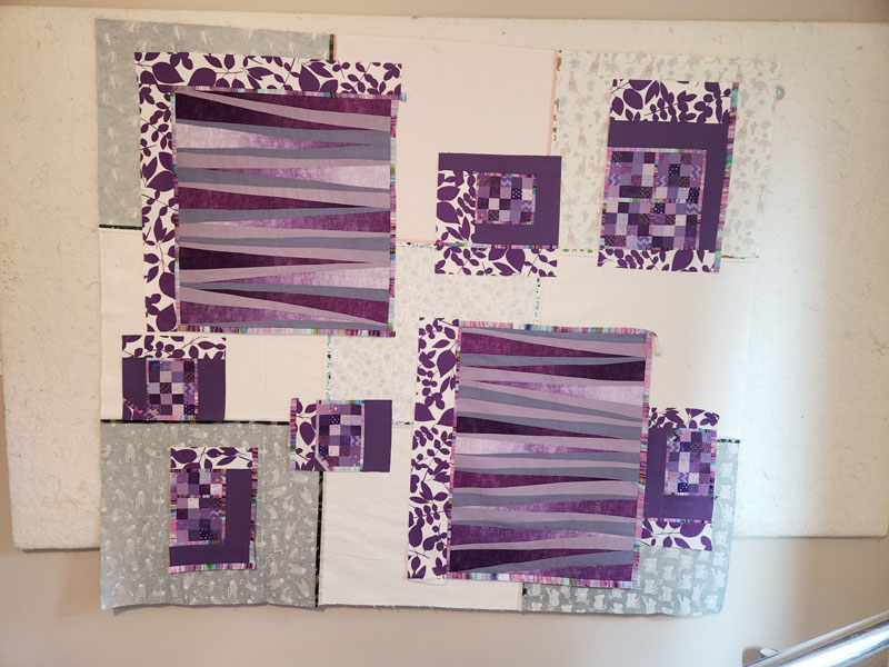 Orphan quilt blocks on design wall against flannel backing