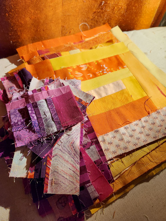 Orange and Purple scrappy quilt blocks stacked up.